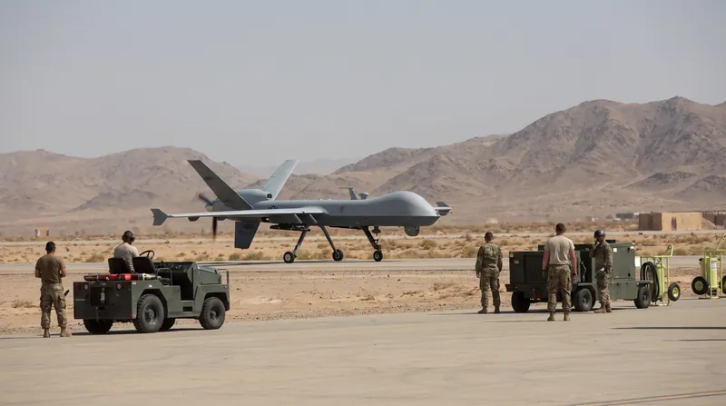 A US MQ-9 Reaper drone flying in a clear blue sky during a military operation.