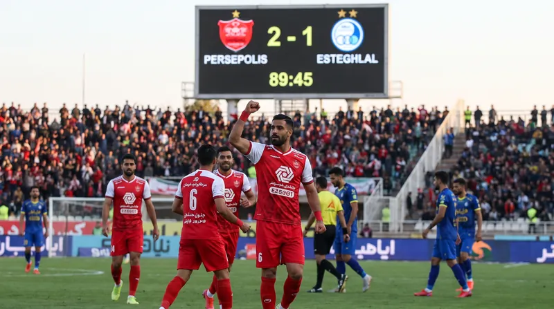 محمدحسین کنعانی‌زادگان با پیراهن قرمز پرسپولیس در زمین فوتبال