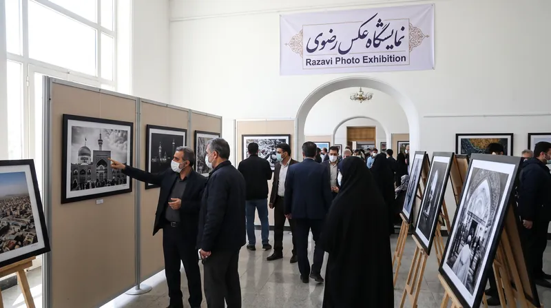 بازدیدکنندگان در حال تماشای عکس‌های به نمایش درآمده در گالری چهاردهمین جشنواره عکس رضوی در استان البرز.