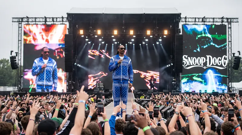 A hip hop rapper performing on stage at a luxury private event in Los Angeles while guests watch.