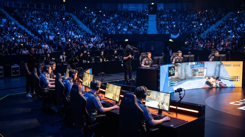 A professional Counter-Strike 2 esports stage in Barcelona with players competing in a major tournament.