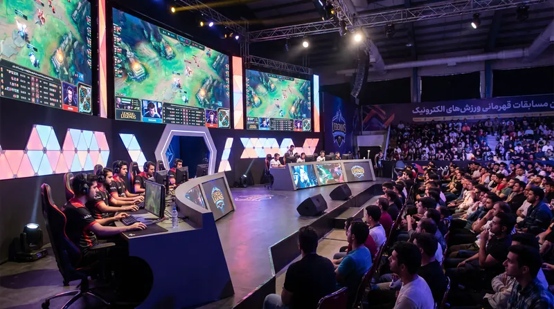 A professional esports player walking onto a massive brightly lit tournament stage with large screens and a crowd in the background.
