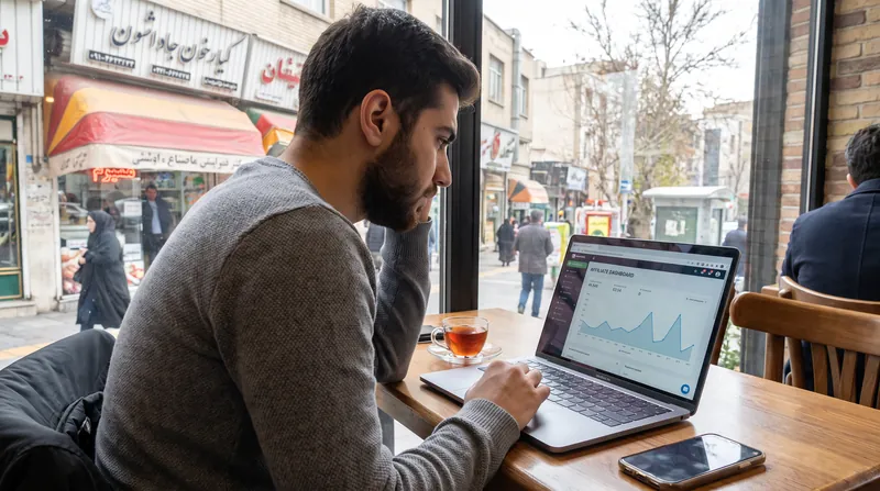 A person sitting at a desk in a home office, typing on a laptop computer.