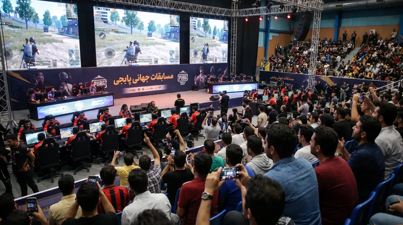 Professional esports players competing on a brightly lit stage during a major PUBG tournament.
