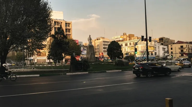 A crowded currency exchange street in Tehran with digital boards showing high exchange rates.