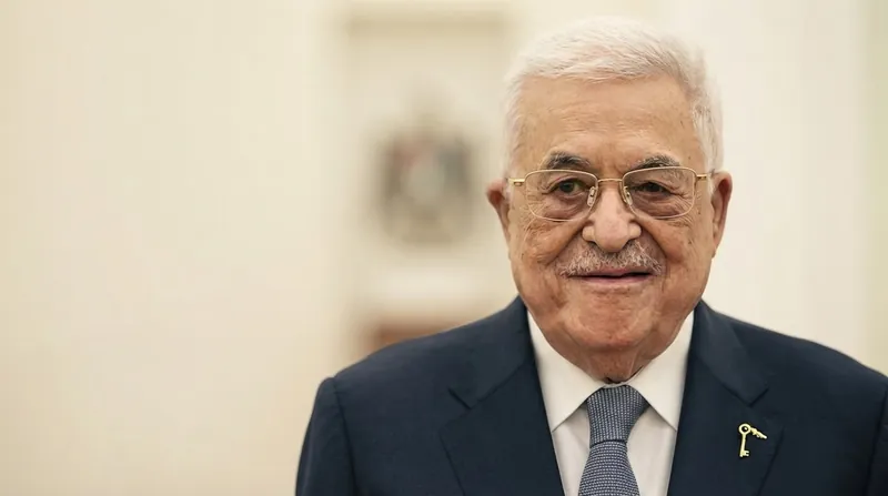 محمود عباس در حال سخنرانی در یک مراسم رسمی با پس‌زمینه پرچم فلسطین